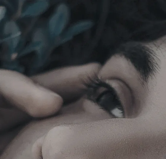 A close view of a man's face during a head massage, eyes closed, hands at his temples.